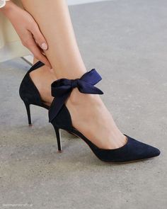 a close up of a woman's legs wearing high heels with a bow on the side