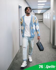 a man walking down a hallway holding a bag and wearing white sneakers with the words spirit written on it