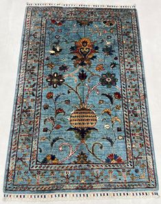 a blue rug with an intricate design on the top and bottom, sitting on a white surface