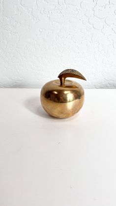 a golden apple sitting on top of a white table