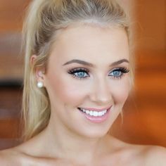 a beautiful blond woman with blue eyes and blonde hair smiling at the camera while wearing a white dress