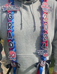 the man is wearing two spiderman lanyards on his neck and holding onto some other lanyards