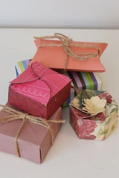 four boxes are stacked on top of each other and tied with twine, one is pink