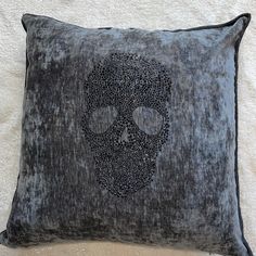 a black and grey pillow with a skull on it