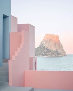 stairs leading up to the ocean with a mountain in the background