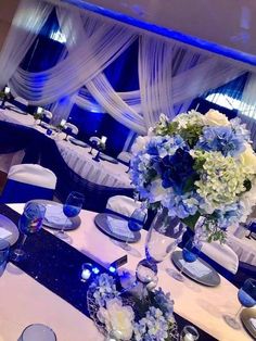 the table is set with blue and white flowers