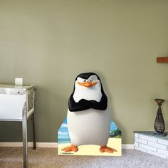 a penguin standing in the corner of a room