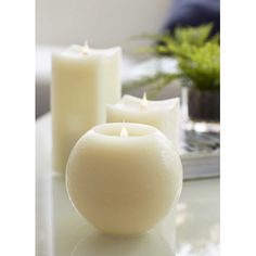 some white candles sitting on top of a table