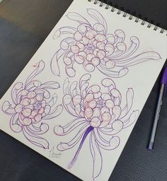 a drawing of flowers on a notebook with a purple pen