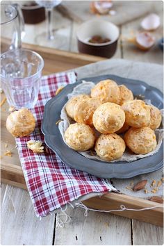 a plate full of biscuits sitting on top of a table next to a glass of water