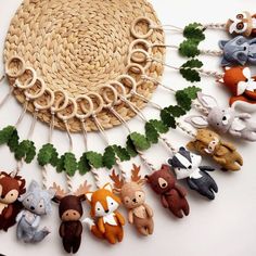 a group of stuffed animals hanging from clothes pins on a string with leaves attached to them