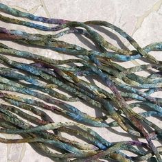 several strands of multicolored glass beads on a white marble surface with blue and green colors