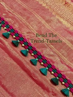 a pink and green saree with tassels on it