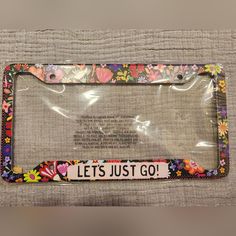 the license plate frame is decorated with flowers and saying, let's just go