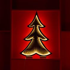 a lit up christmas tree on a red wall