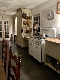 a kitchen with an oven, stove and dining room table in front of the sink