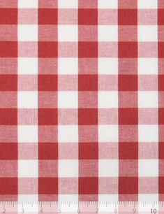 a red and white checkered fabric with a ruler in front of the plaid pattern