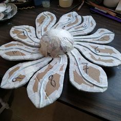 a paper mache flower sitting on top of a wooden table