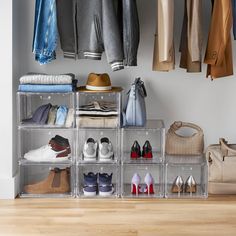 an organized closet with clear plastic bins filled with shoes and handbags on the floor