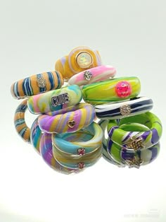 several bracelets are stacked on top of each other in different colors and designs,