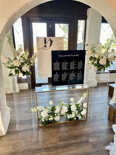 flowers are placed in clear acrylic vases at the entrance to a ceremony