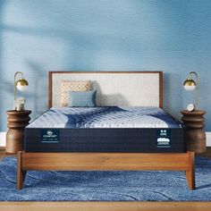 the mattress is in front of a blue wall with two lamps on either side of it