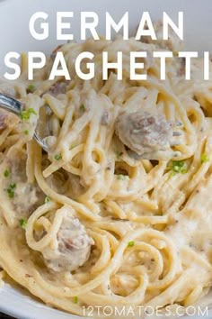 a white bowl filled with pasta covered in meatballs and gravy next to a fork