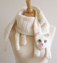 a white knitted scarf with a cat face on it's front and bottom