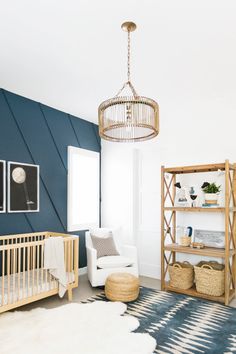 a baby's room with blue walls and white furniture