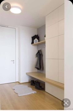 a white closet with wooden flooring and shelves