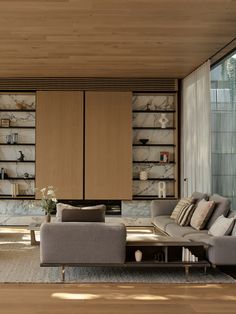 a living room filled with furniture and lots of bookshelves on the wall behind it