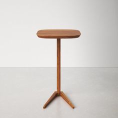 a small wooden table sitting on top of a white floor