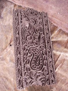 an intricately carved book sitting on top of a stone slab in the middle of a floor