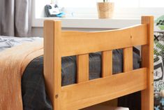 a bed with a wooden headboard and foot board next to a window in a bedroom