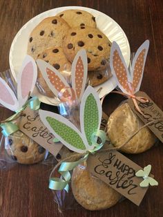 chocolate chip cookies wrapped in cellophane and decorated with bunny ears are on a plate