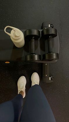 a person sitting on a skateboard with their feet propped up next to some cups