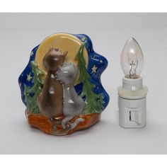 a small light bulb sitting next to a ceramic figurine