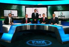 four men in suits and ties sitting at a table on fox sports's set