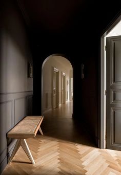 an empty hallway with a bench in the middle