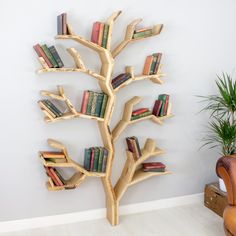 a wooden tree with books on it in front of a wall mounted bookcases