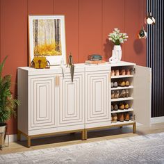 a white cabinet sitting next to a potted plant