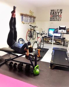 a man is doing exercises on the exercise bench in his home gym with bikes and other equipment