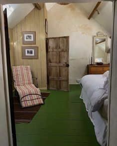 an open door leading to a bedroom with green flooring