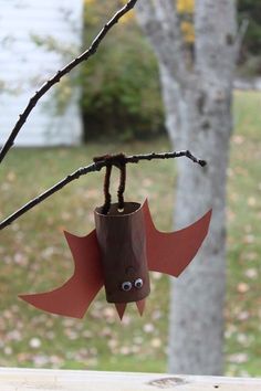 a paper roll bat hanging from a tree branch