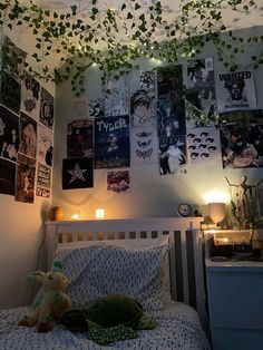 an unmade bed with posters on the wall above it and a stuffed animal in front