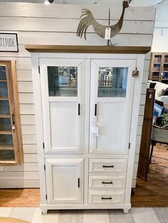 an armoire with two doors and drawers on display in a room filled with furniture