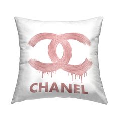 a chanel pillow with pink paint drips on it and the words,'chanel