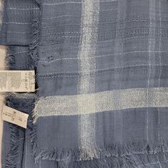 a blue and white plaid blanket with tags on it