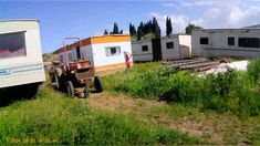 an old truck is parked in the grass next to some mobile home trailers and trailer homes