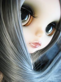 an image of a doll with grey hair and big eyes looking at something in the distance